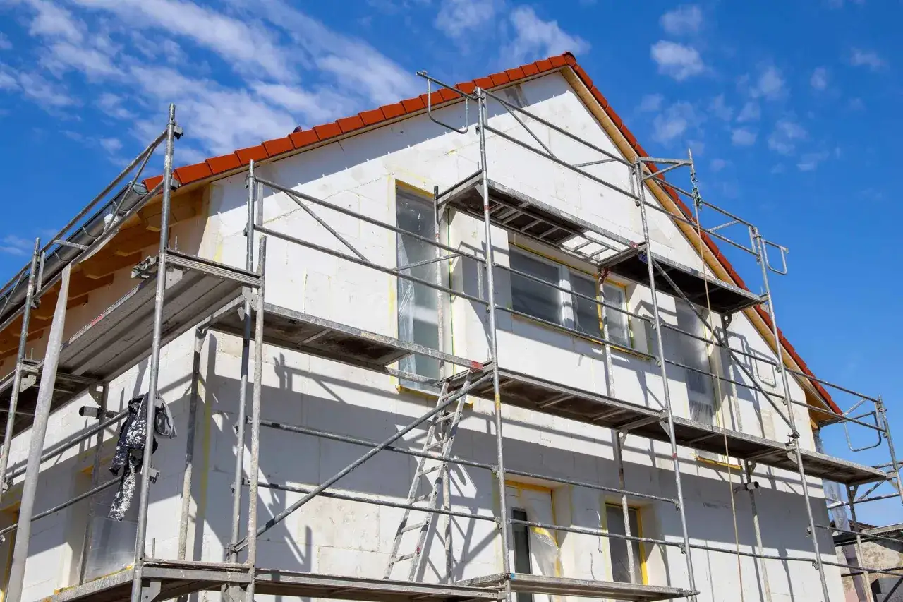 Haus mit Ger&uuml;st f&uuml;r Fenstertausch. Die Kosten f&uuml;r den Fenstertausch sind hier ein wichtiges Thema, da die alten Fenster ersetzt werden.