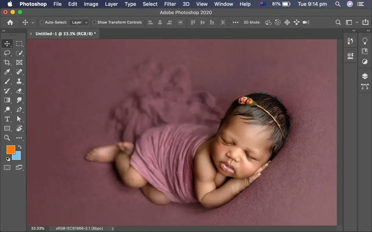 Urocze niemowlę śpi owinięte w r&oacute;żowy materiał. To zdjęcie to przykład nauki photoshopa, gdzie można poprawić detale.