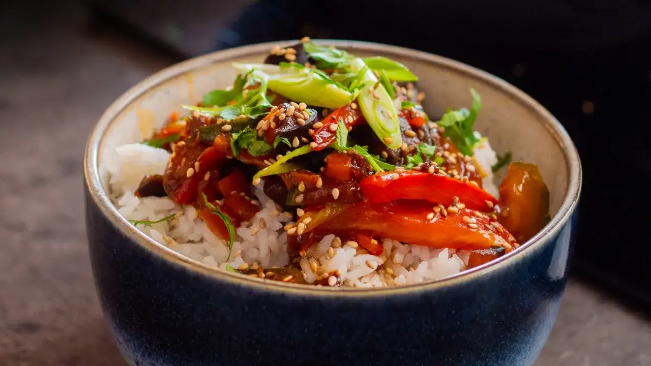 Reissch&uuml;ssel mit gebratenem Gem&uuml;se und einer k&ouml;stlichen teriyaki sauce, garniert mit Fr&uuml;hlingszwiebeln und Sesam.