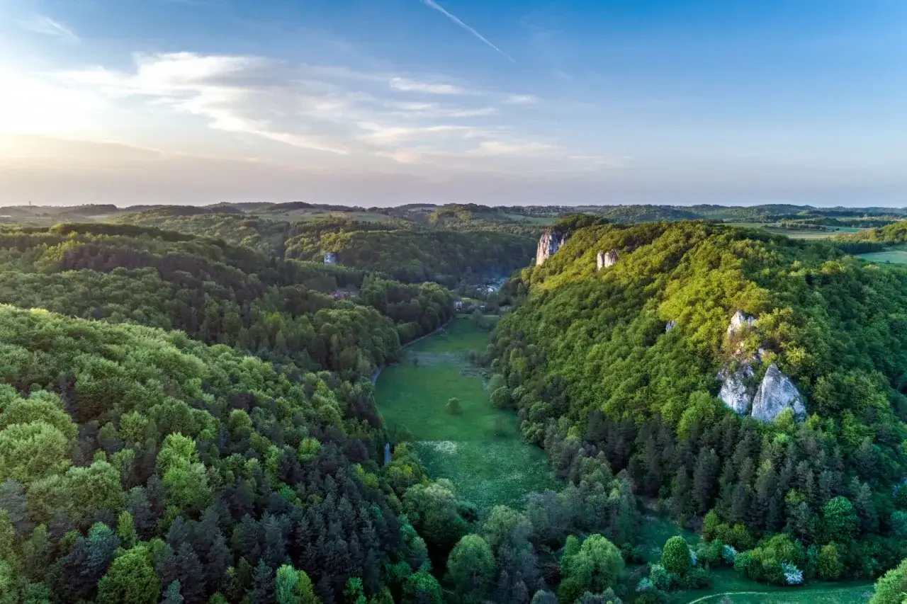 Malownicza dolina Będkowska z wapiennymi skałkami i bujną zielenią las&oacute;w o zachodzie słońca.