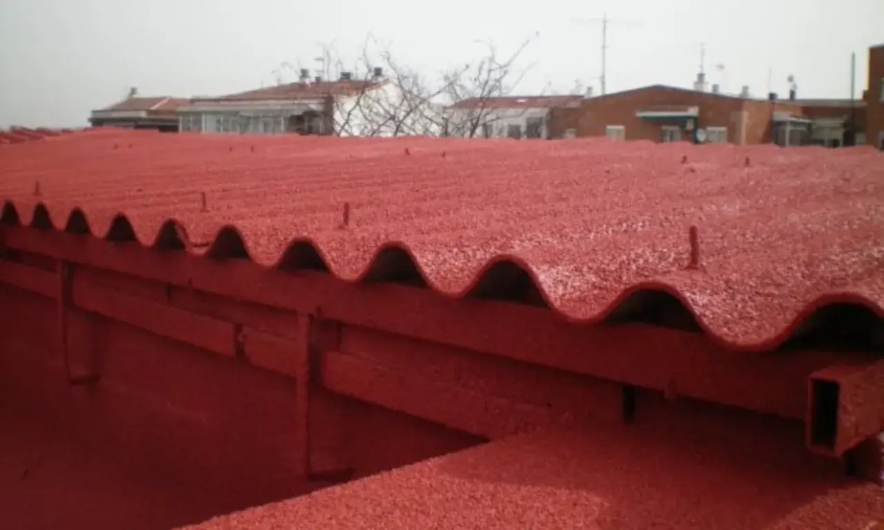 Tejado de uralita rojo, reci&eacute;n pintado, con el ruido callejero de fondo.