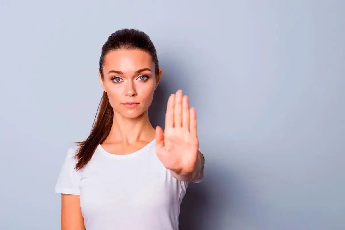 Mujer con mano extendida, aprendiendo a decir no.