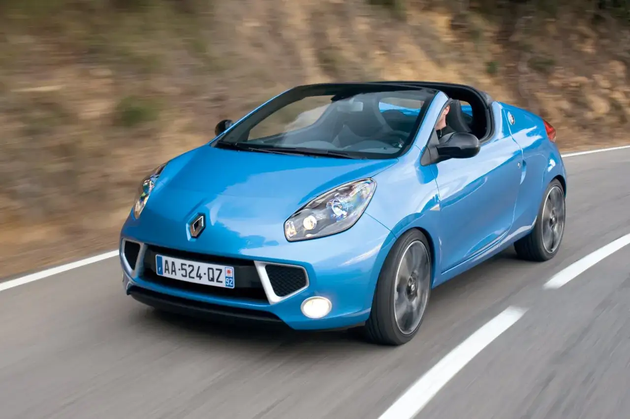 Niebieski kabriolet marki Renault Twingo RS na krętej drodze.