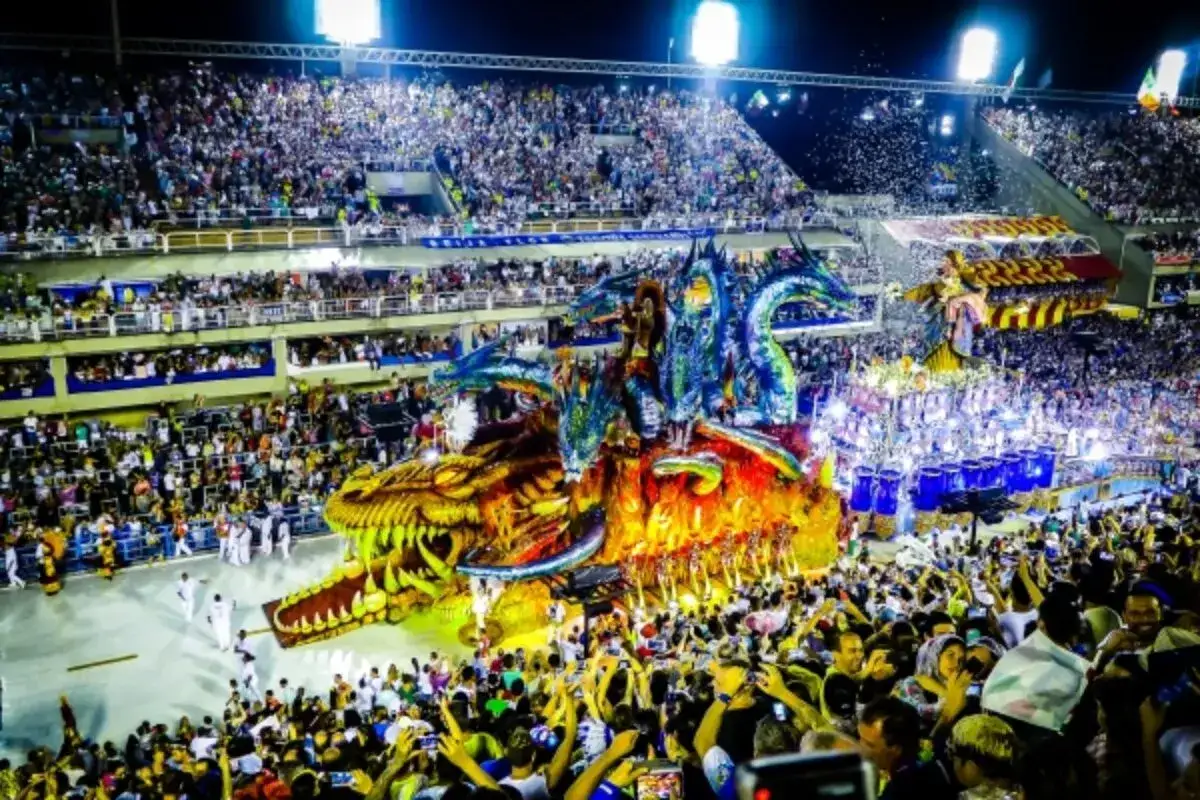 Spektakularny **Rio de Janeiro karnawał** z ogromną, barwną platformą w kształcie smoka i tłumami widzów na trybunach.