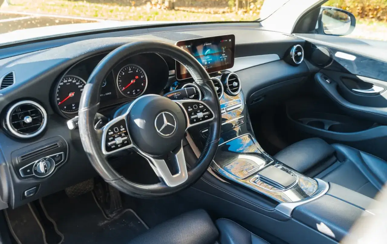 Wnętrze Mercedesa GLC 200 4Matic: kierownica, deska rozdzielcza z ekranem multimediów i konsola środkowa.