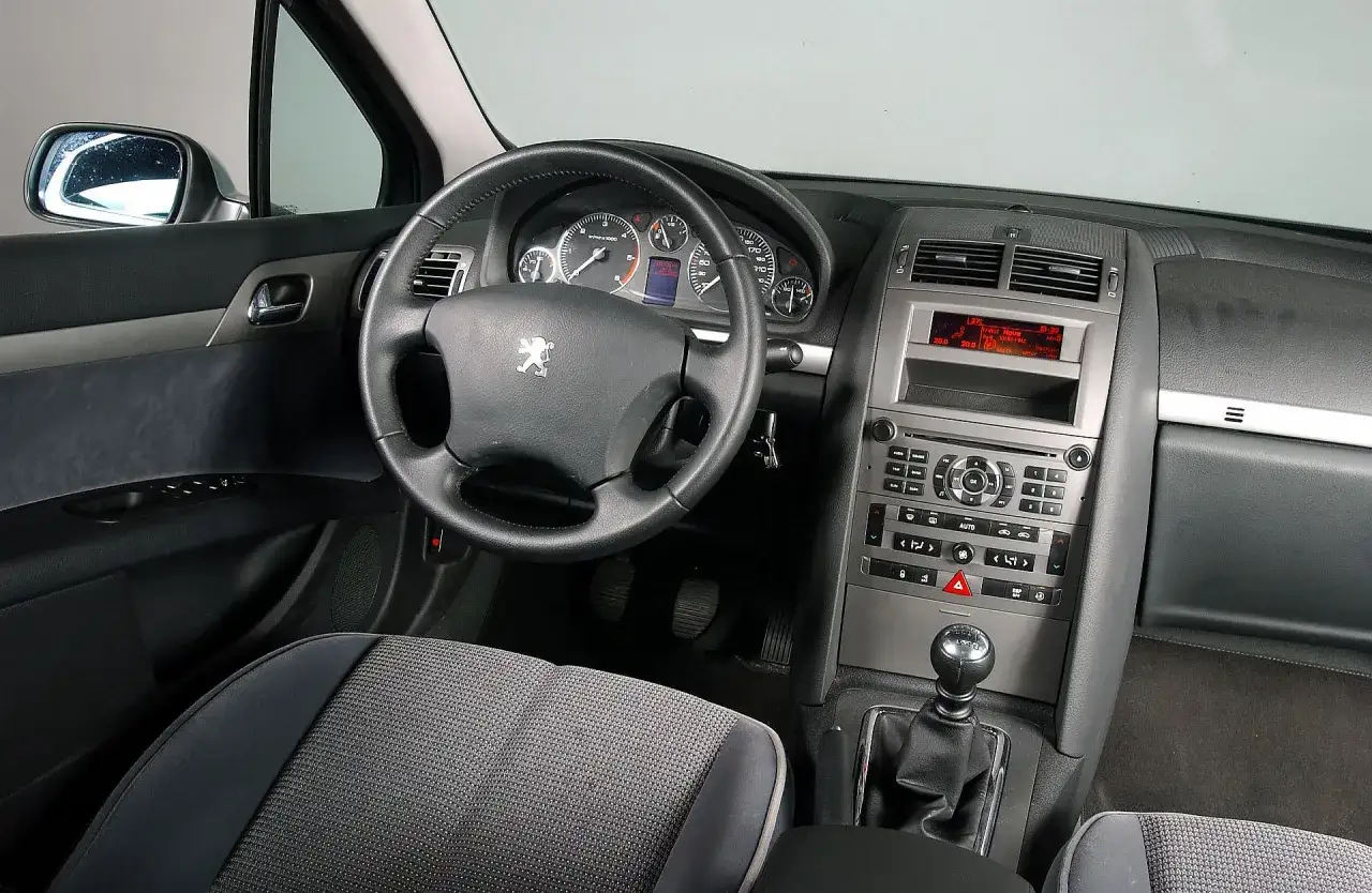 Wnętrze Peugeot 407 2.0 HDI: kierownica, deska rozdzielcza z radiem i nawigacją, dźwignia zmiany biegów.