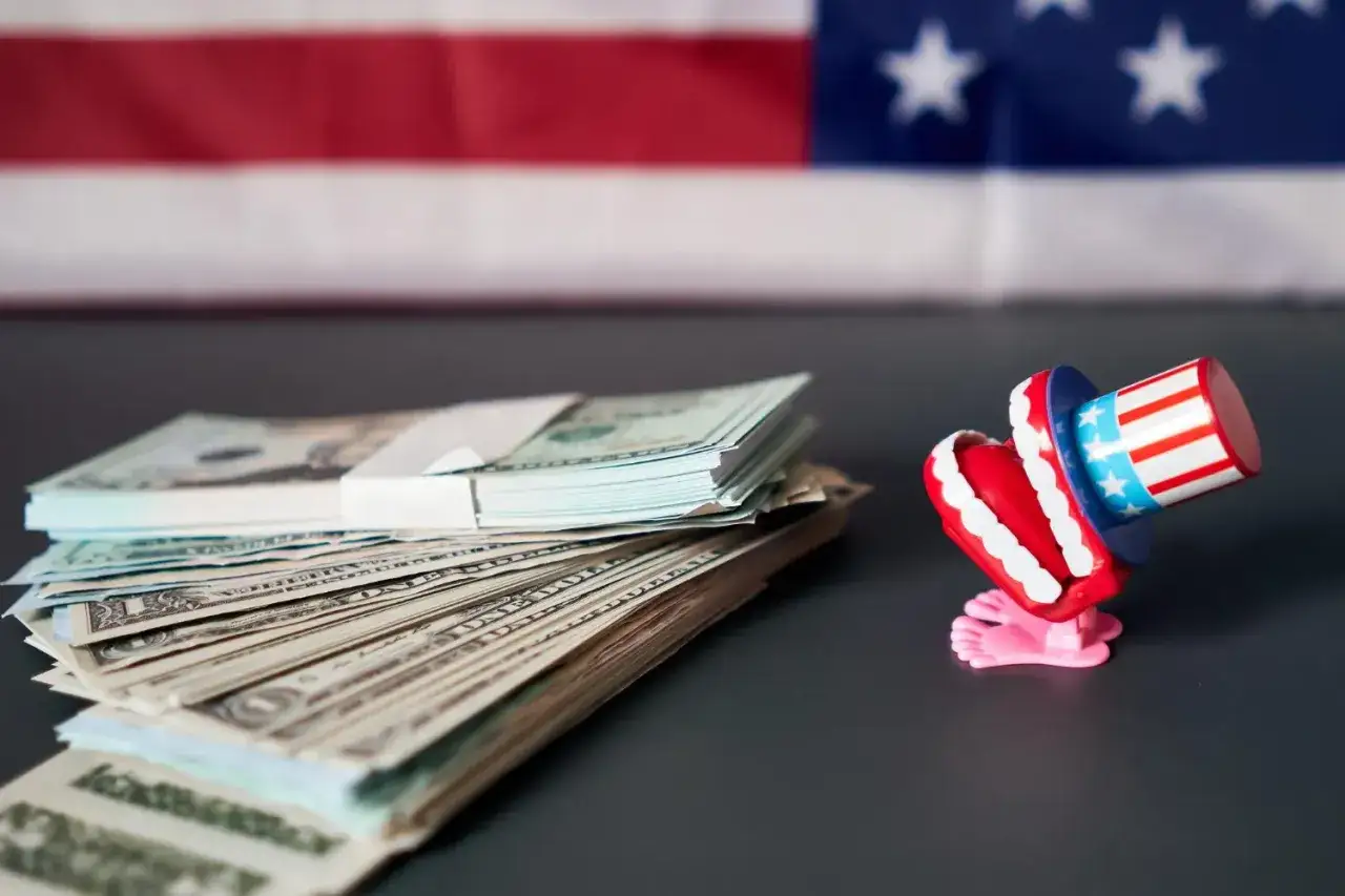 Stos banknotów dolarowych i zabawne zęby w amerykańskiej czapce. Zastanawiasz się, co kupić w USA do Polski?