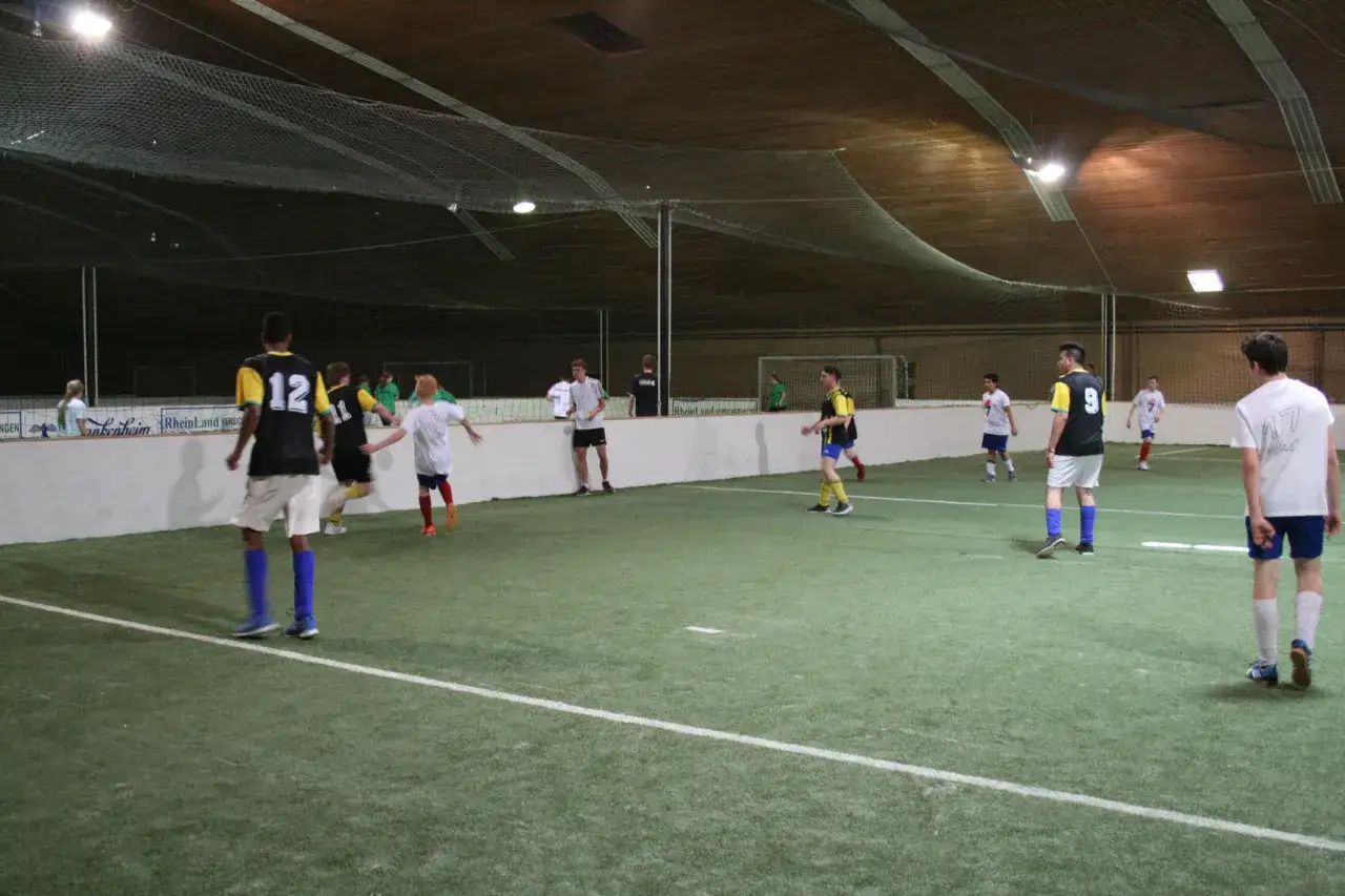 Fu&szlig;ballspiel im bergische Sportzentrum Solingen. Spieler in bunten Trikots auf Kunstrasen.