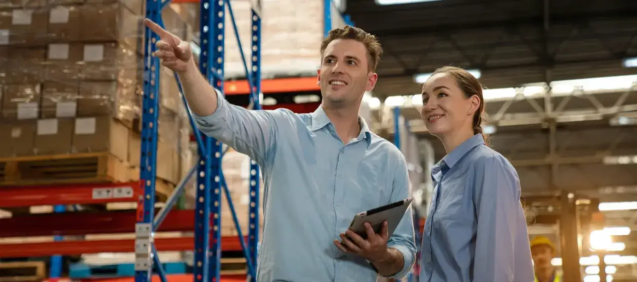 Man pekar och kvinna lyssnar i lager. De verkar lära sig om hur man plugga logistik.