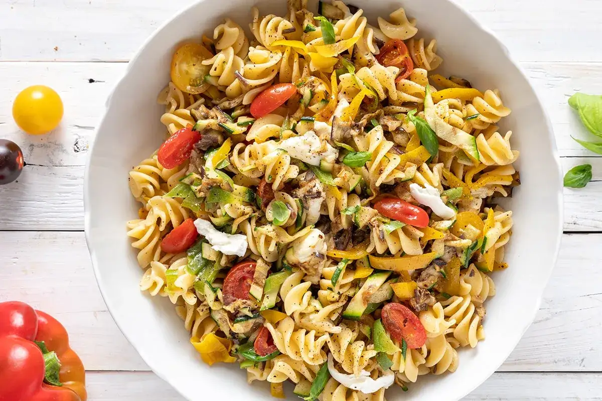 Pasta fredda con verdure miste, pomodorini e mozzarella. Perfetta per ricette pasta fredda veloci e sfiziose.