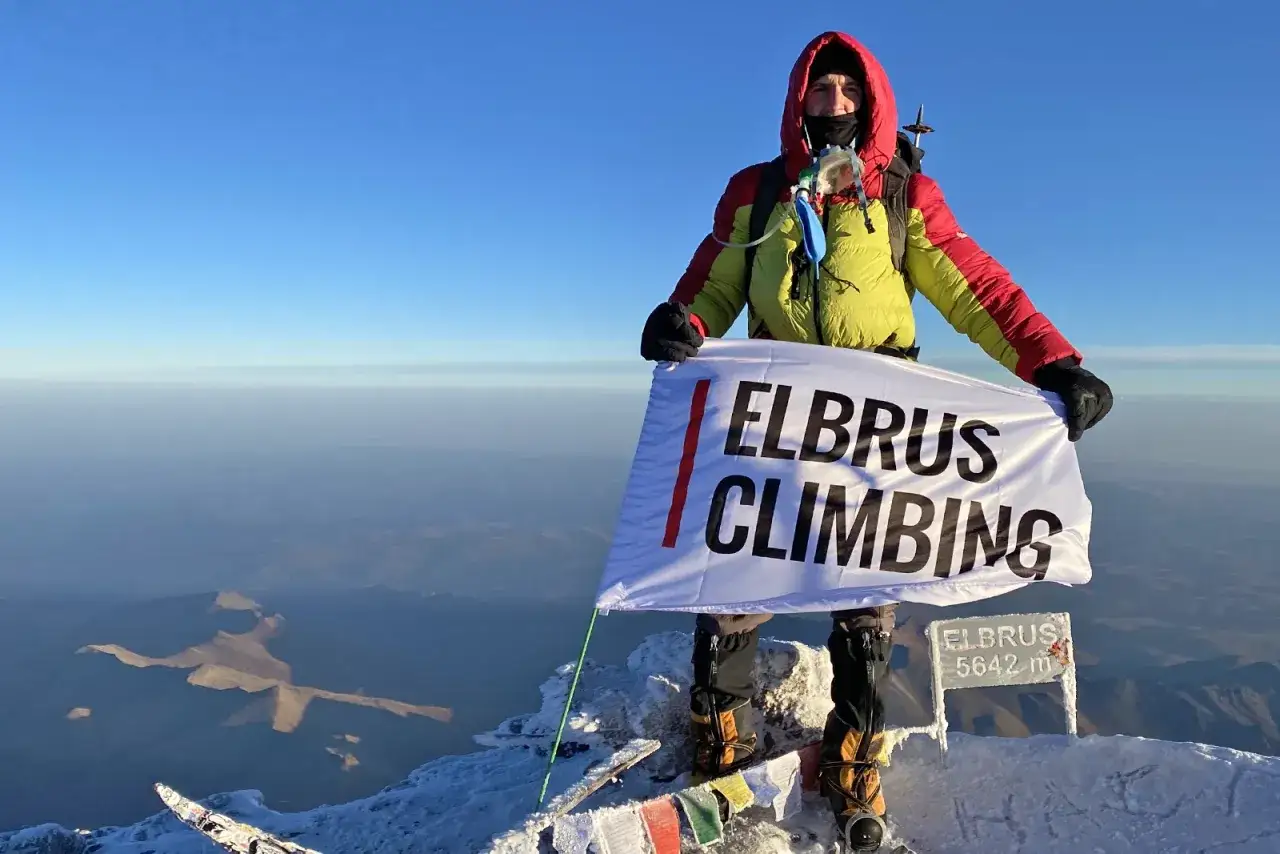 Zdobywca najwyższego szczytu Kaukazu, Elbrusu (5642 m), z flagą 