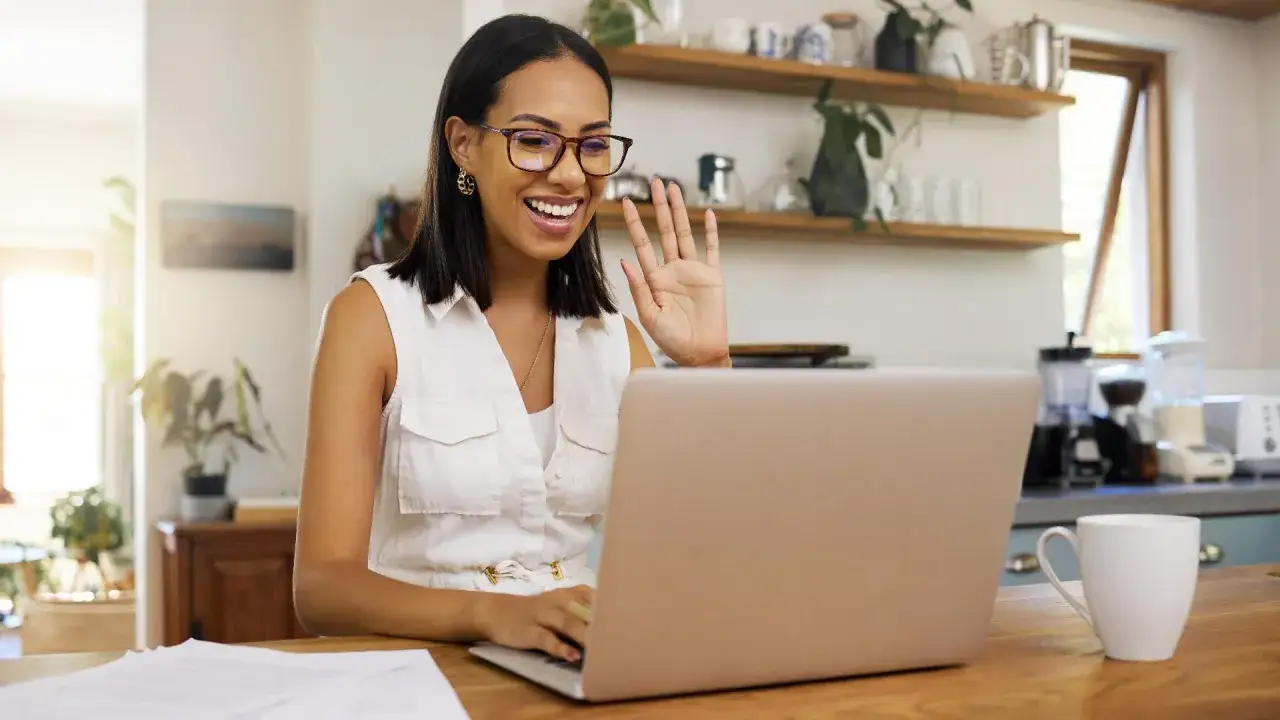 Donna sorridente saluta durante un colloquio online. Ottimi consigli per affrontare al meglio questa situazione.