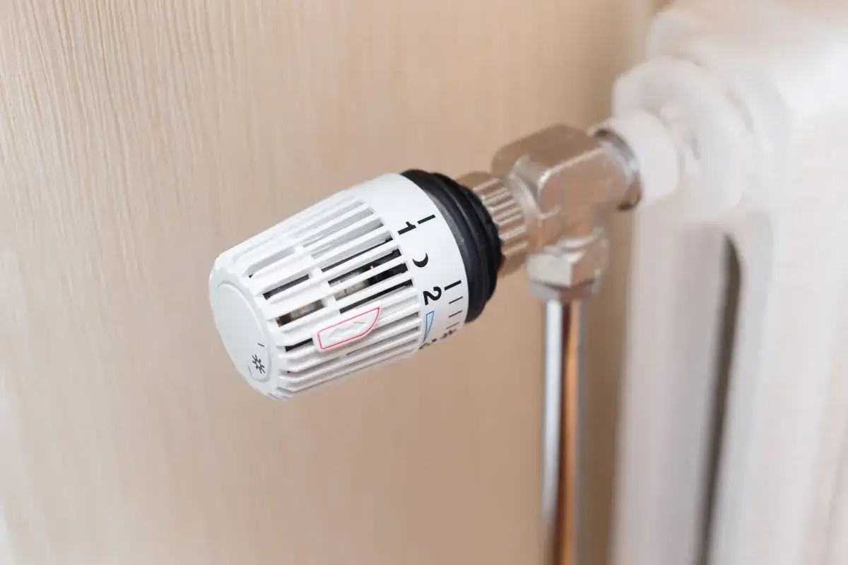 Termostato su radiatore bianco, impostato su 1.5, per la termoregolazione impianti.