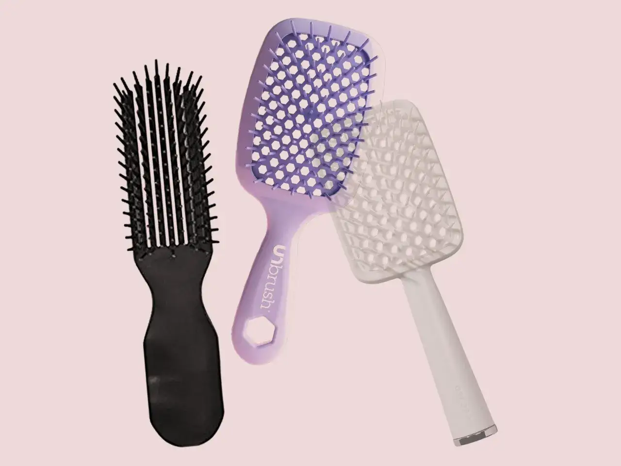 Tre spazzole per capelli: una nera, una viola e una bianca, perfette per districare e pettinare capelli ricci.