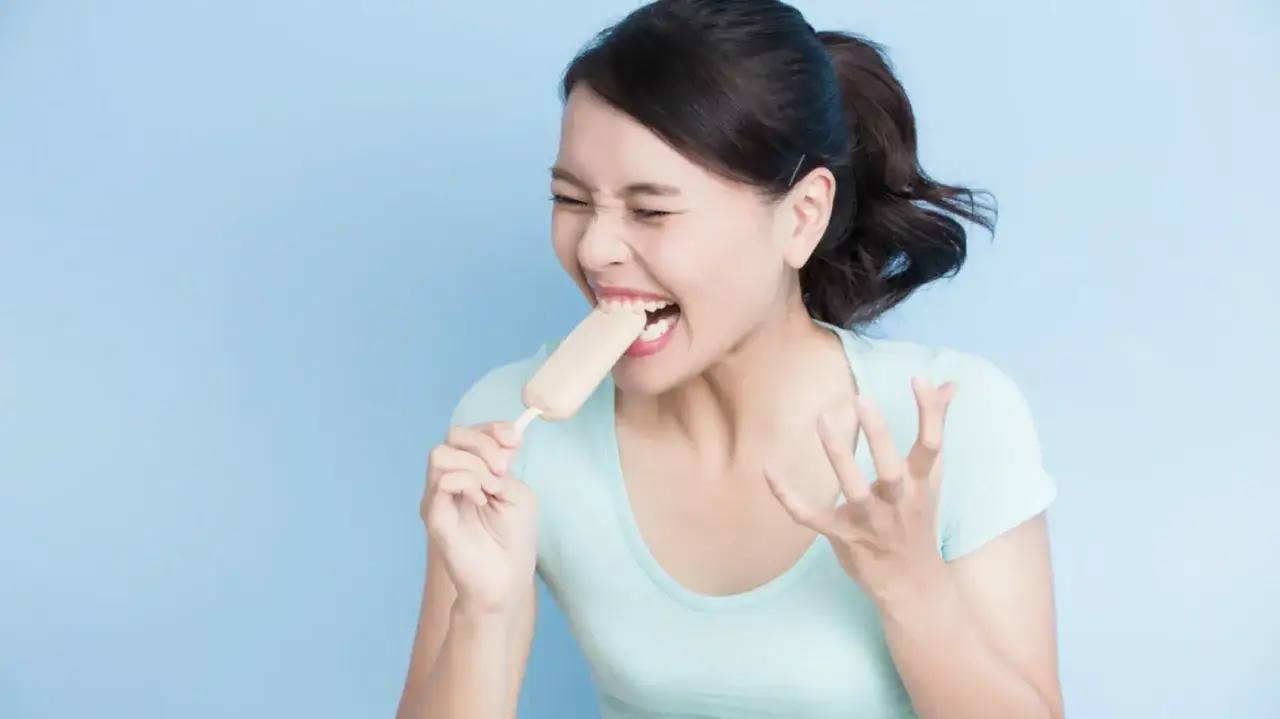 Donna con denti sensibili rimedio immediato, soffre il freddo di un gelato.