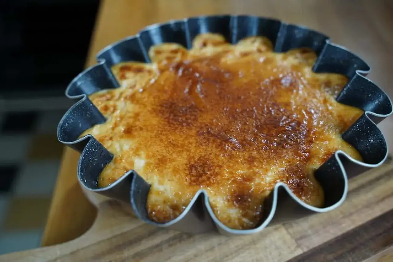 Un d&eacute;licieux g&acirc;teau de riz tout juste sorti du four, avec une cro&ucirc;te caram&eacute;lis&eacute;e dor&eacute;e et app&eacute;tissante, dans un moule &agrave; bords ondul&eacute;s.