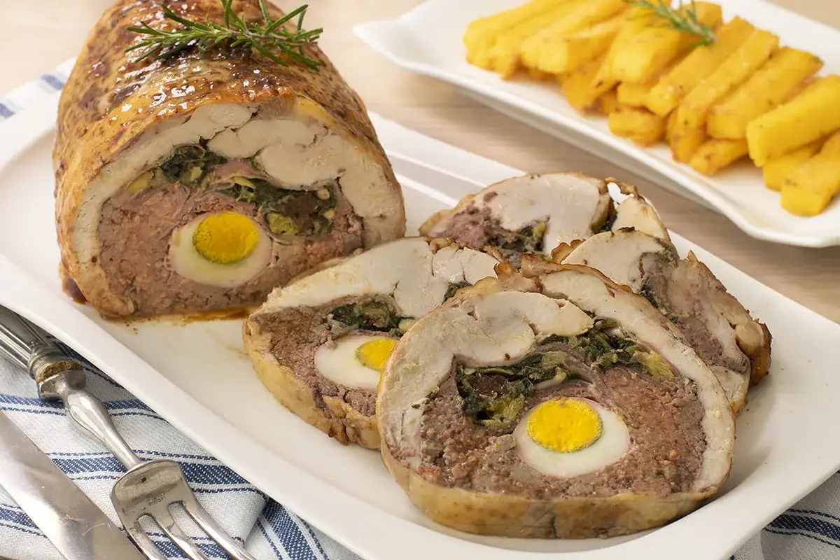 Pollo asado relleno con huevo duro y espinacas, servido con patatas fritas.