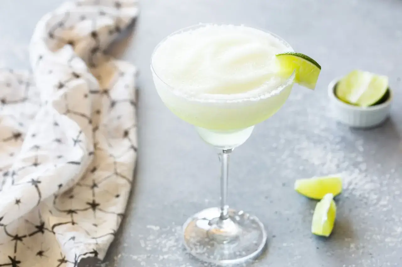 En frostig frozen margarita med limeklyfta, redo att avnjutas.