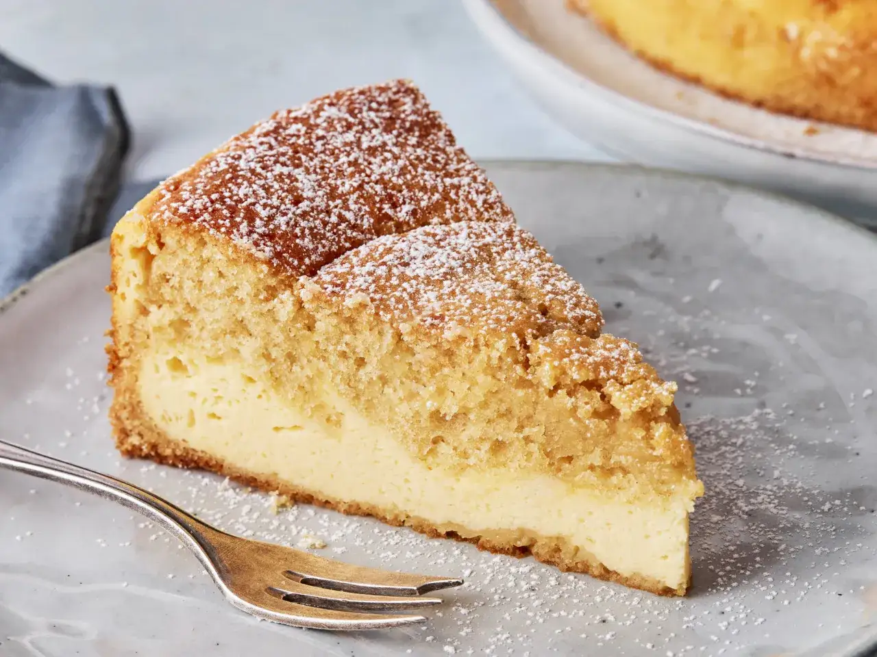 Ein Stück cremiger Käsekuchen mit Streuseln und Puderzucker. Dreh dich um, Kuchen, du siehst köstlich aus!