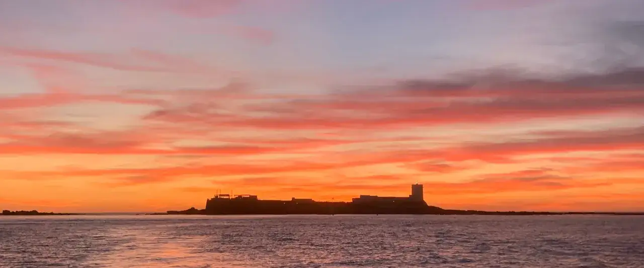 Atardecer espectacular en Sancti Petri. El castillo se recorta contra un cielo de fuego, un paseo marítimo de ensueño.