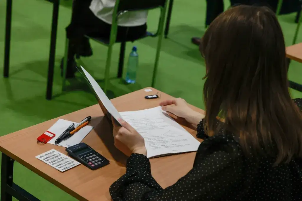 nauczyciel matematyki piszący dokumenty przy biurku w szkole