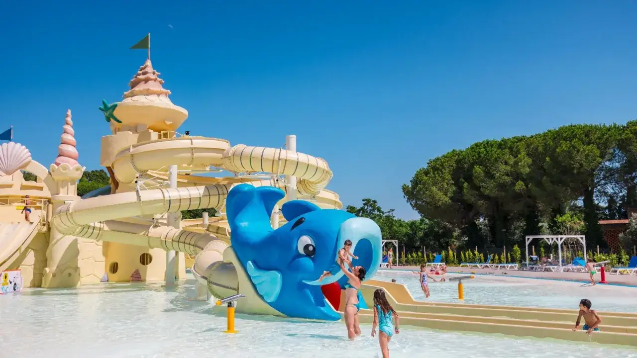 Divertimento acquatico al Santapomata Camping con scivoli a forma di castello e un simpatico delfino blu.