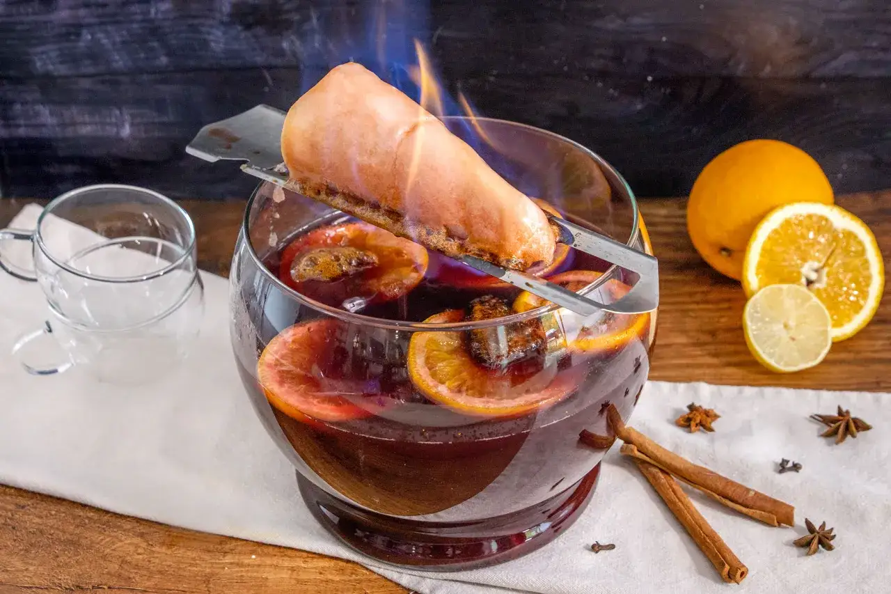 Feuerzangenbowle brennt! Ein Zuckerhut tropft glühend in die heiße, orangen- und zimtduftende Bowle. So trinkt man Feuerzangenbowle.