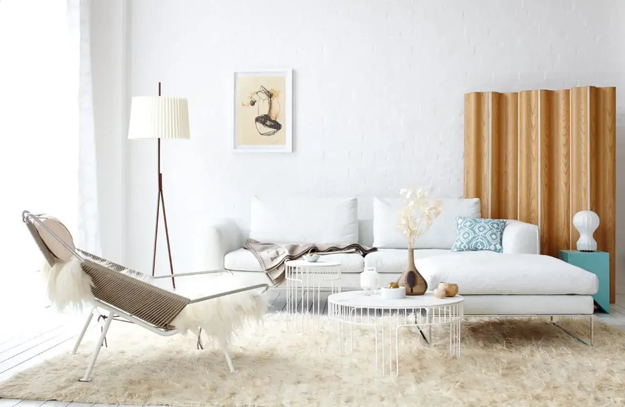 Kleines Wohnzimmer vorher-nachher: Helles, skandinavisches Design mit weißem Sofa, Fellteppich, Designer-Sessel und Holzakzenten.