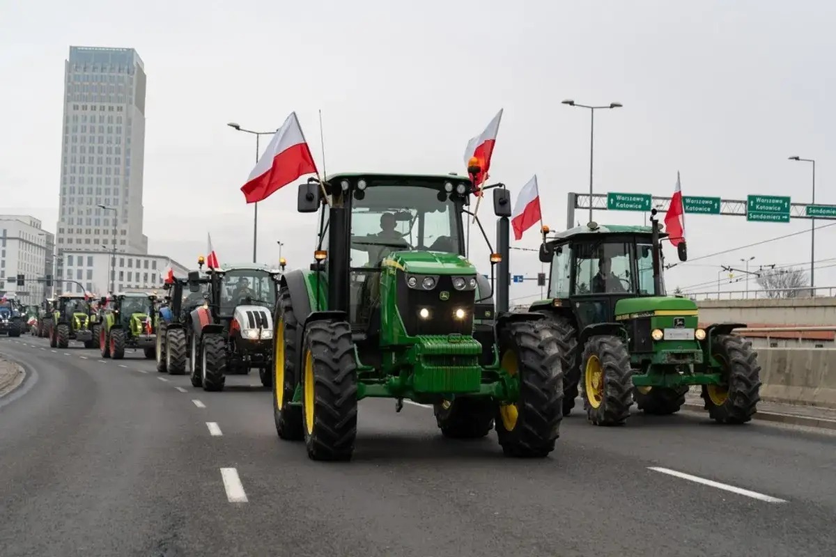 Traktory z polskimi flagami na drodze, protest rolnik&oacute;w przeciwko europejskiemu zielonemu ładowi.
