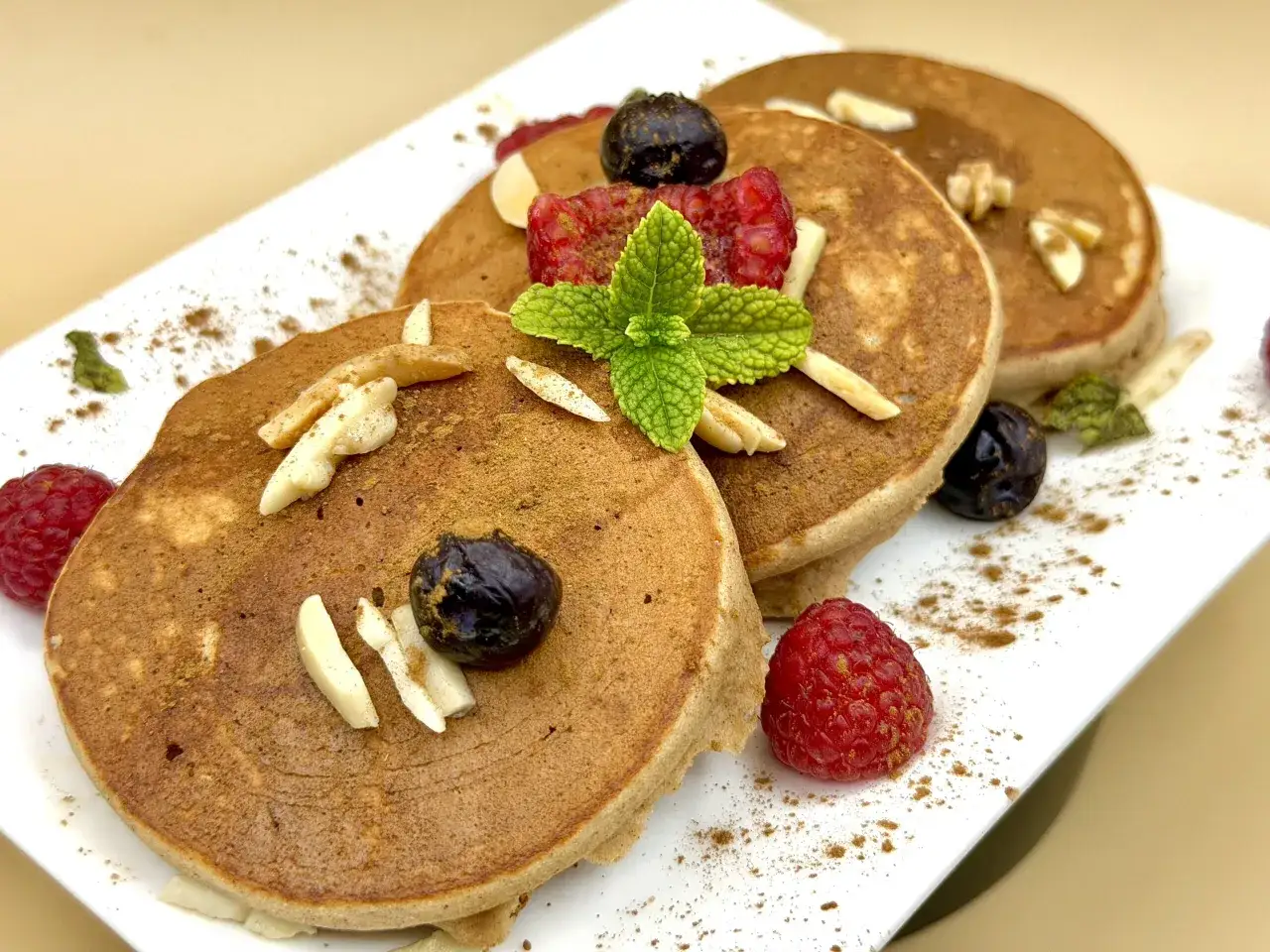 Pancake farina di castagne con lamponi, mirtilli, mandorle e menta, spolverati di cannella.