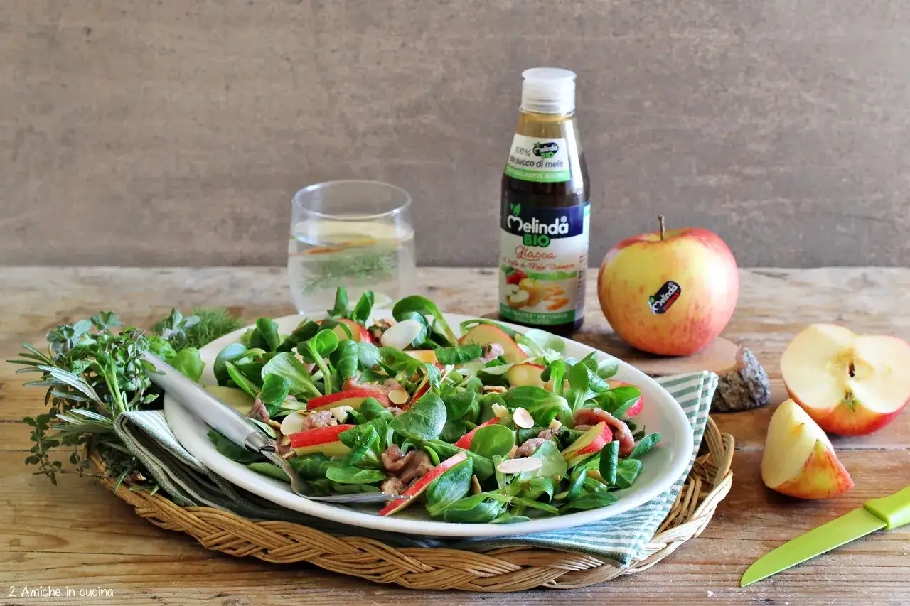 Insalata fresca con mele e noci, condita con glassa all'aceto di mele, per scoprire i benefici dell'aceto di mele.
