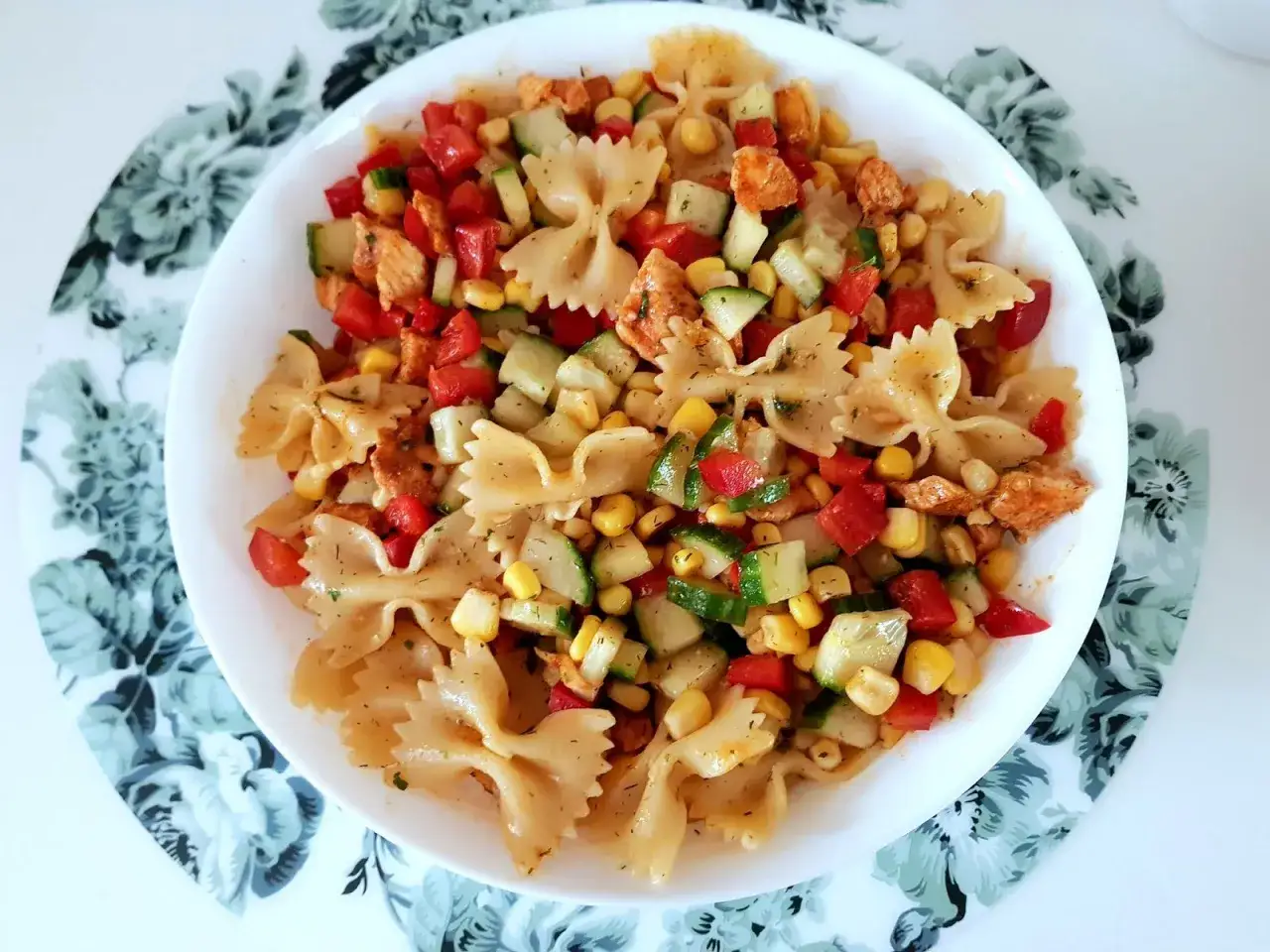 Kolorowa sałatka z makaronem farfalle, kurczakiem, kukurydzą, pomidorkami i ogórkiem. Idealna sałatka z makaronem na szybko.