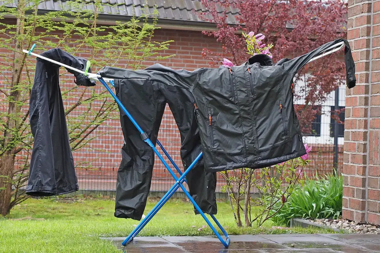Schwarze Funktionskleidung trocknet auf einem W&auml;schest&auml;nder im Freien. Das richtige Funktionskleidung waschen ist wichtig f&uuml;r die Langlebigkeit.
