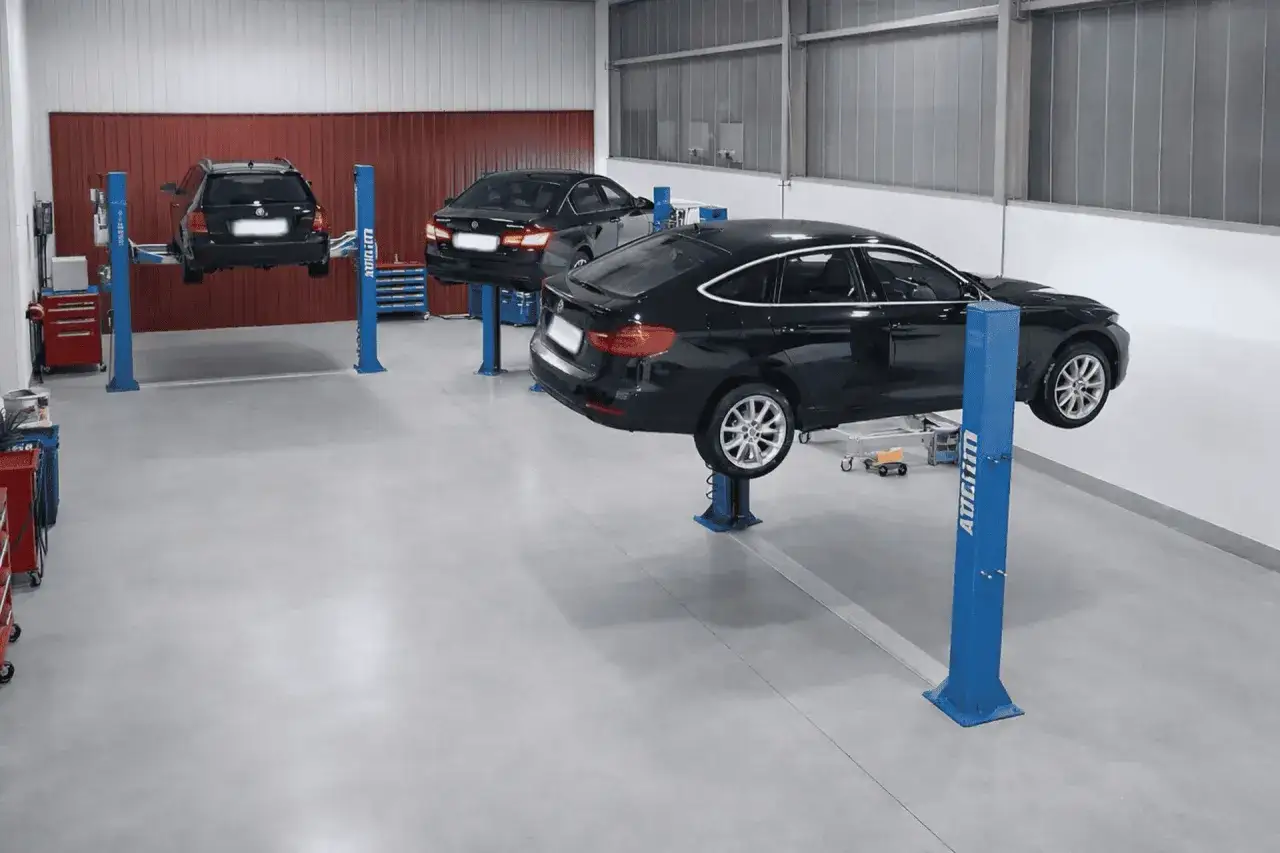Autos in Werkstatt auf Hebebühnen für den Wintercheck. Informieren Sie sich über die Wintercheck Auto Kosten.