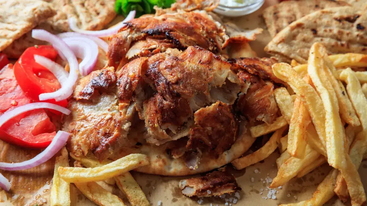 En gyros med krispiga pommes, tomater, l&ouml;k och pitabr&ouml;d. Perfekt f&ouml;r ett gyros krydda recept.