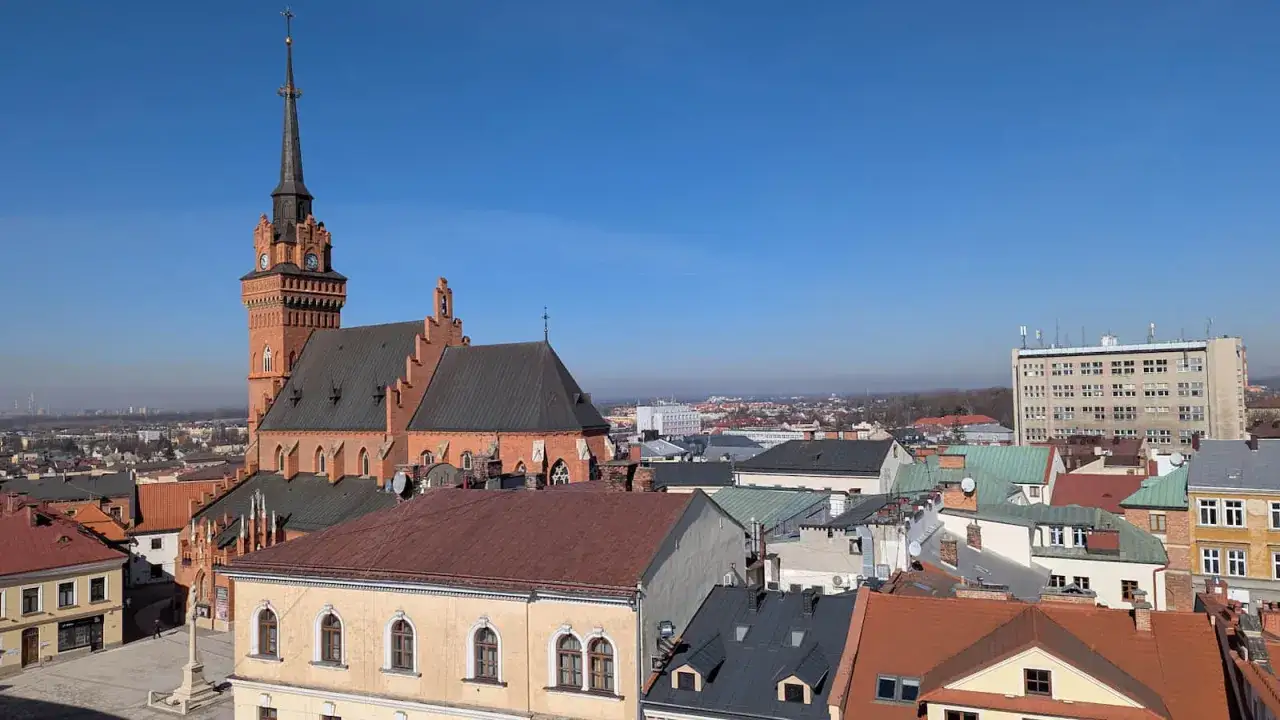 Widok na zabytkowe centrum Tarnowa z dominującą katedrą. Wśr&oacute;d dach&oacute;w widać nowoczesny budynek, tworząc ciekawy kontrast. To jedne z wielu tarnowskich atrakcji.