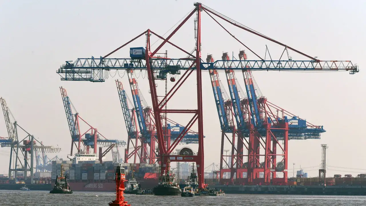 Große Hafenkräne laden einen Containerschiff. Die Kosten für den terminal handling charge sind hier sichtbar.