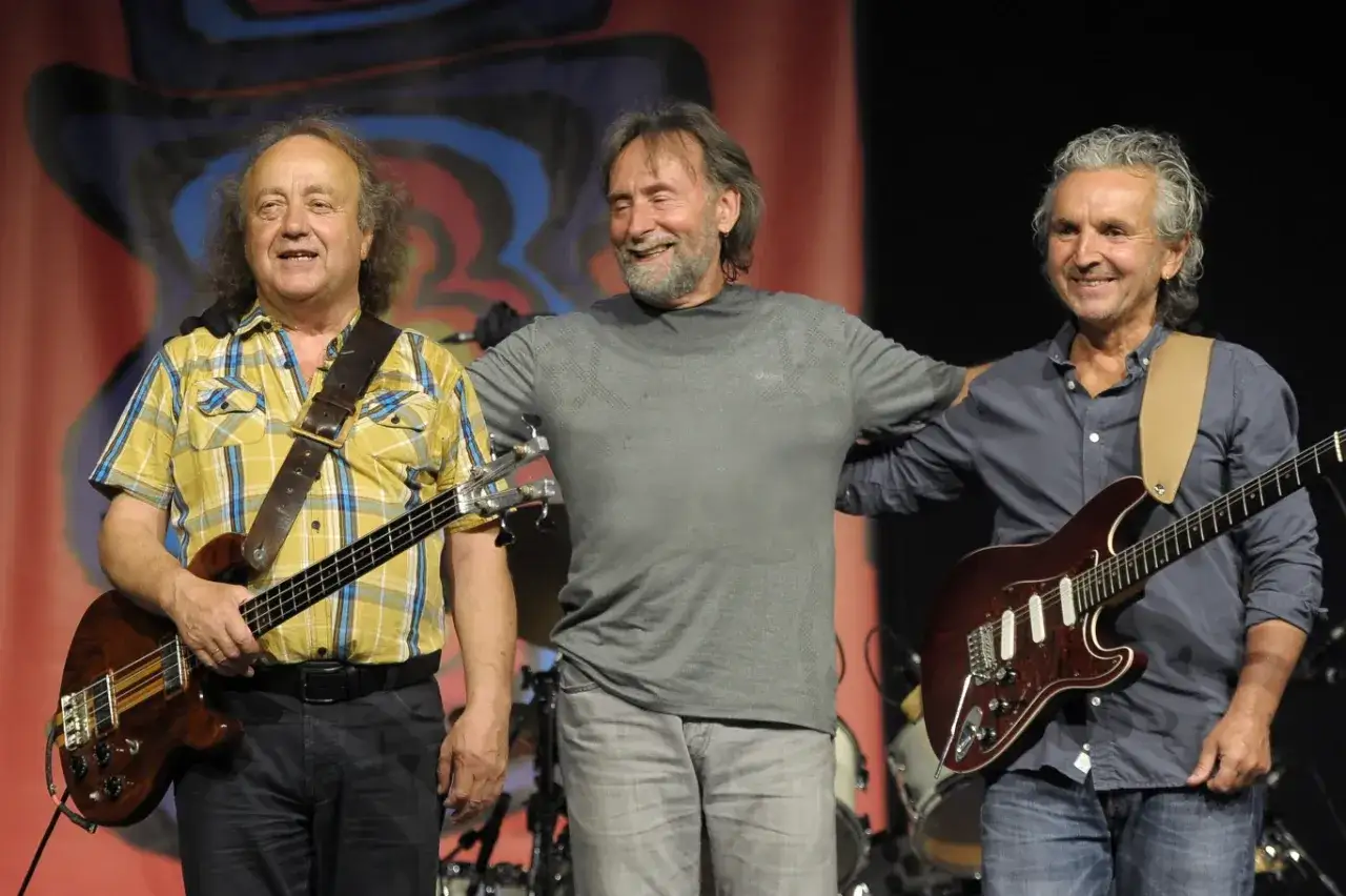 Trzech muzyków na scenie. Po lewej założyciel zespołu SBB z basem, w środku wokalista, po prawej gitarzysta.