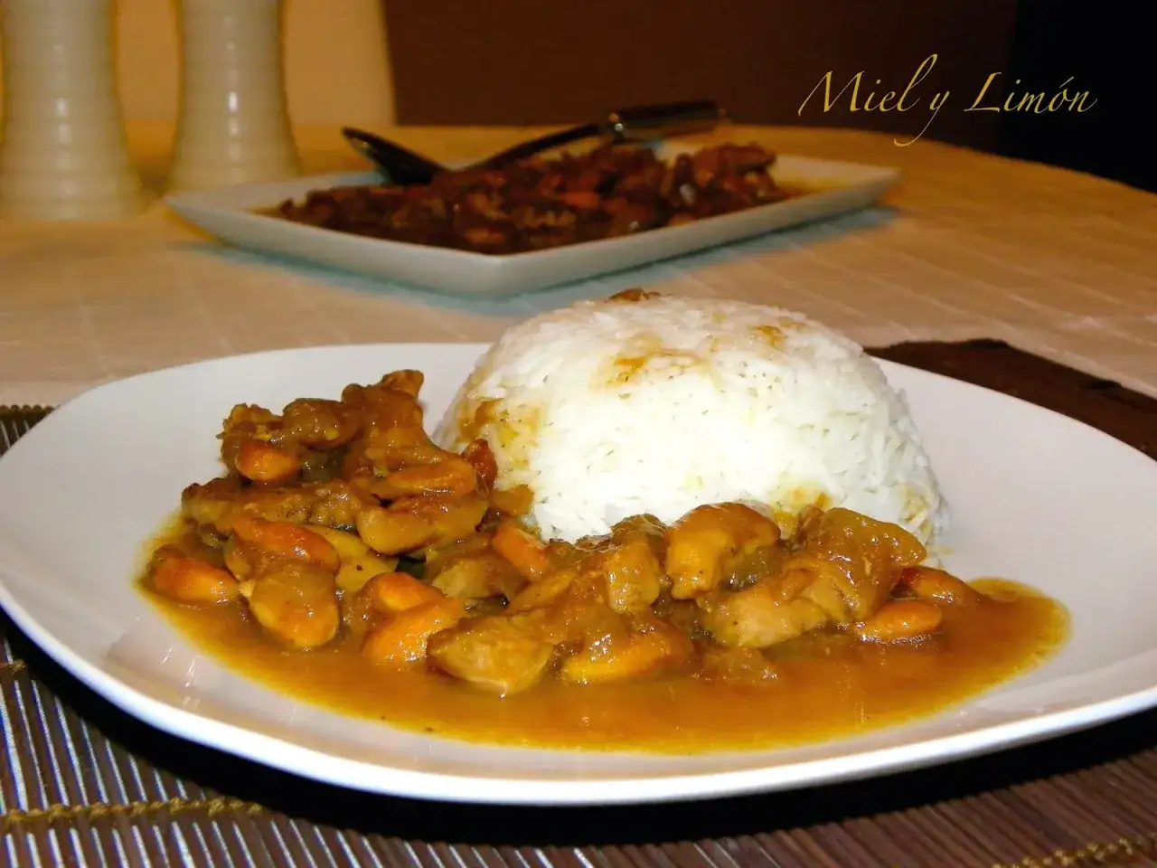 Delicioso pollo con almendras en salsa dorada, servido junto a una monta&ntilde;a de arroz blanco.