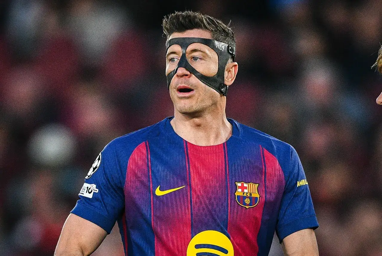 Robert Lewandowski w masce ochronnej na twarzy, w koszulce FC Barcelony. Fani zastanawiają się, ile kosztuje Robert Lewandowski.