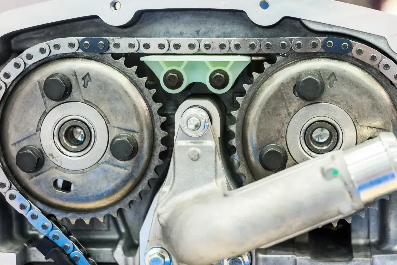 Mechanizm rozrządu z łańcuchem i kołami zębatymi. Pokazuje różnicę między silnikiem kolizyjnym a bezkolizyjnym, gdzie zawory i tłoki nie mogą się zderzyć.