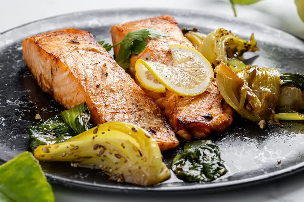 Succulento salmone in friggitrice ad aria, servito con verdure croccanti e spicchi di limone.