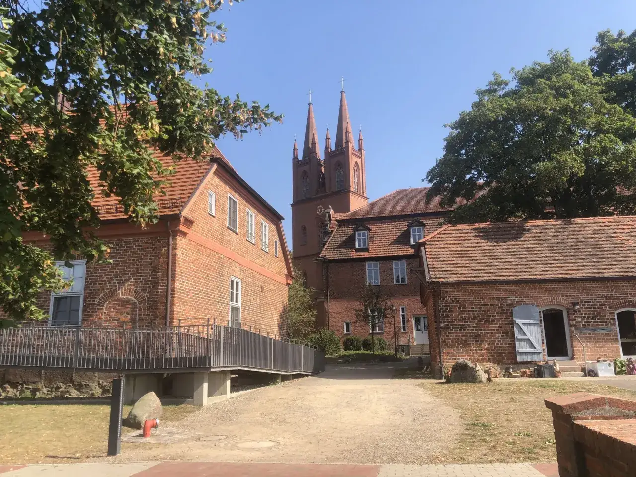 Zwei Kirchtürme ragen über die roten Ziegeldächer des Klosters Dobbertin.