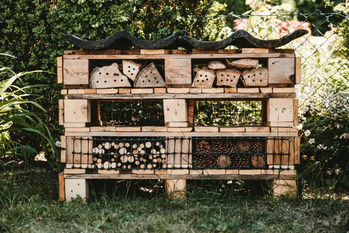 Domek dla owadów z palet, pełen naturalnych materiałów. Świetne upcycling przykłady dla ogrodu.