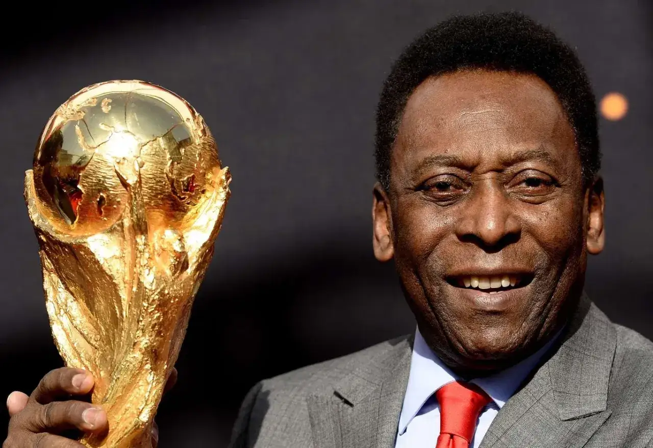 Uśmiechnięty Pel&eacute; trzymający Złotą Nike. Ile złotych piłek ma Pel&eacute;? Trzy!