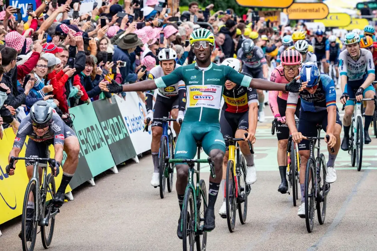 Radfahrer im grünen Trikot mit ausgestreckten Armen, ein Moment der Freude während der Cube Tour de France.