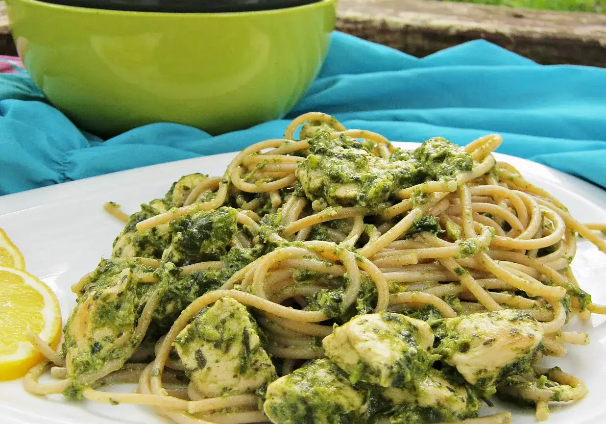 Pyszny makaron z pesto i kurczakiem, podany z plasterkami cytryny. Idealny na letni obiad.