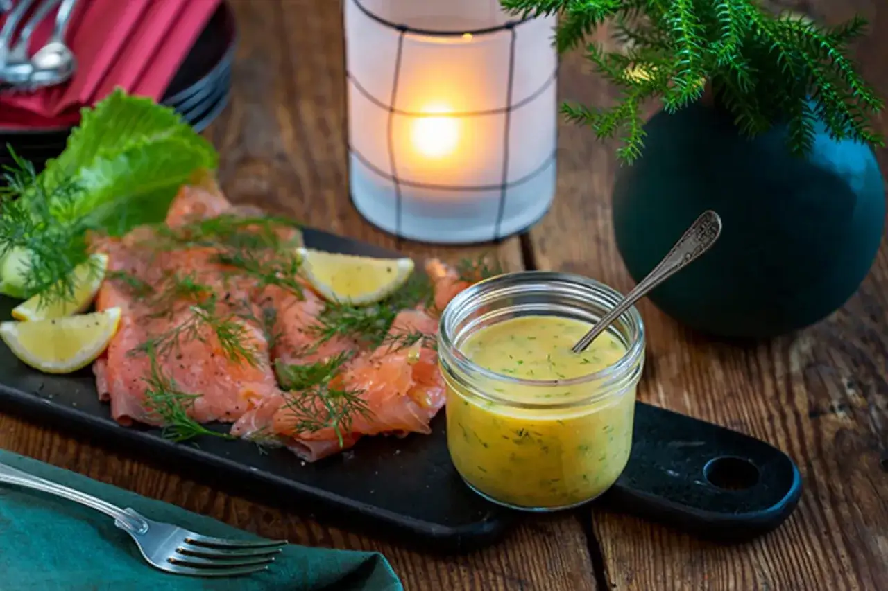 Enkel gravlaxs&aring;s i en burk bredvid gravad lax med dill och citron. En mysig bordsdekoration med ljus och gr&ouml;nska.