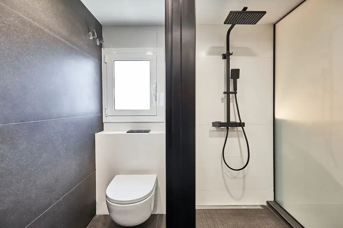 Ba&ntilde;os peque&ntilde;os con ducha, uno con inodoro y ventana, el otro con ducha moderna.