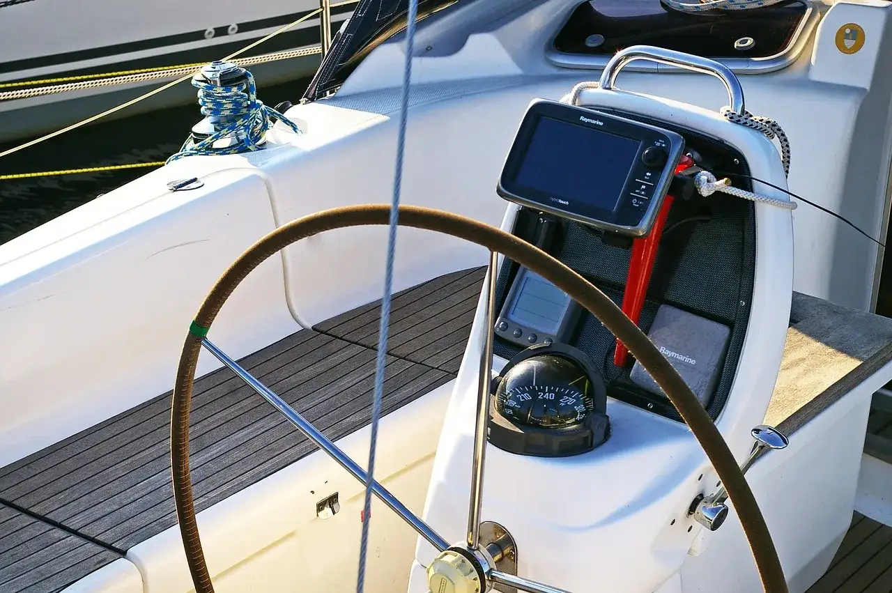 Timone, bussola e GPS su una barca a vela. Il timoniere, chi guida la barca, si affida a questi strumenti per la navigazione.